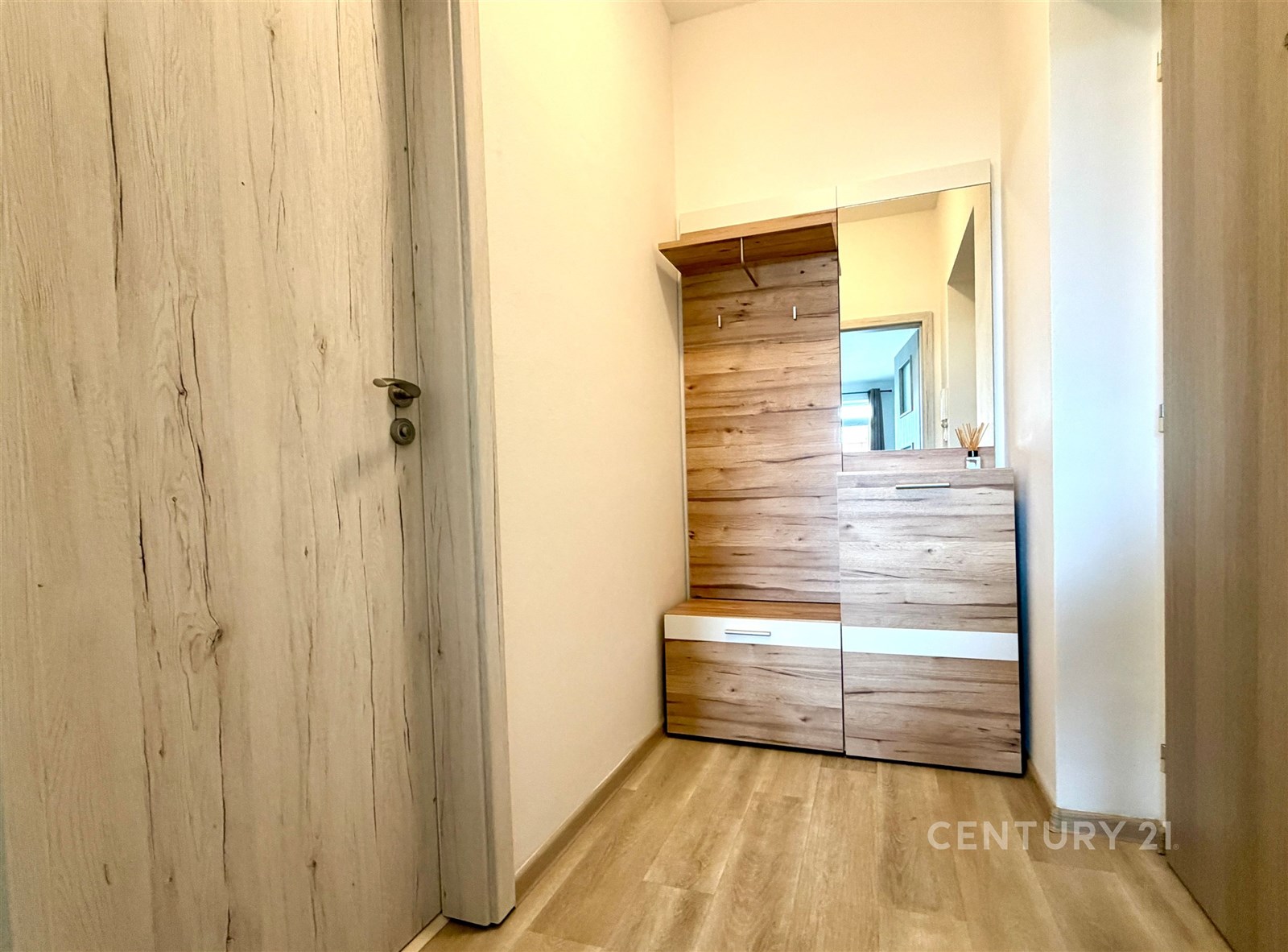 Předsíň s dřevěným nábytkem, laminátovou podlahou 