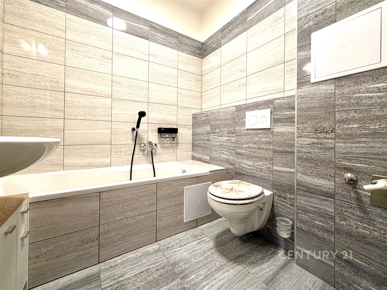 Moderní koupelna s šedými obklady, závěsnou toalet