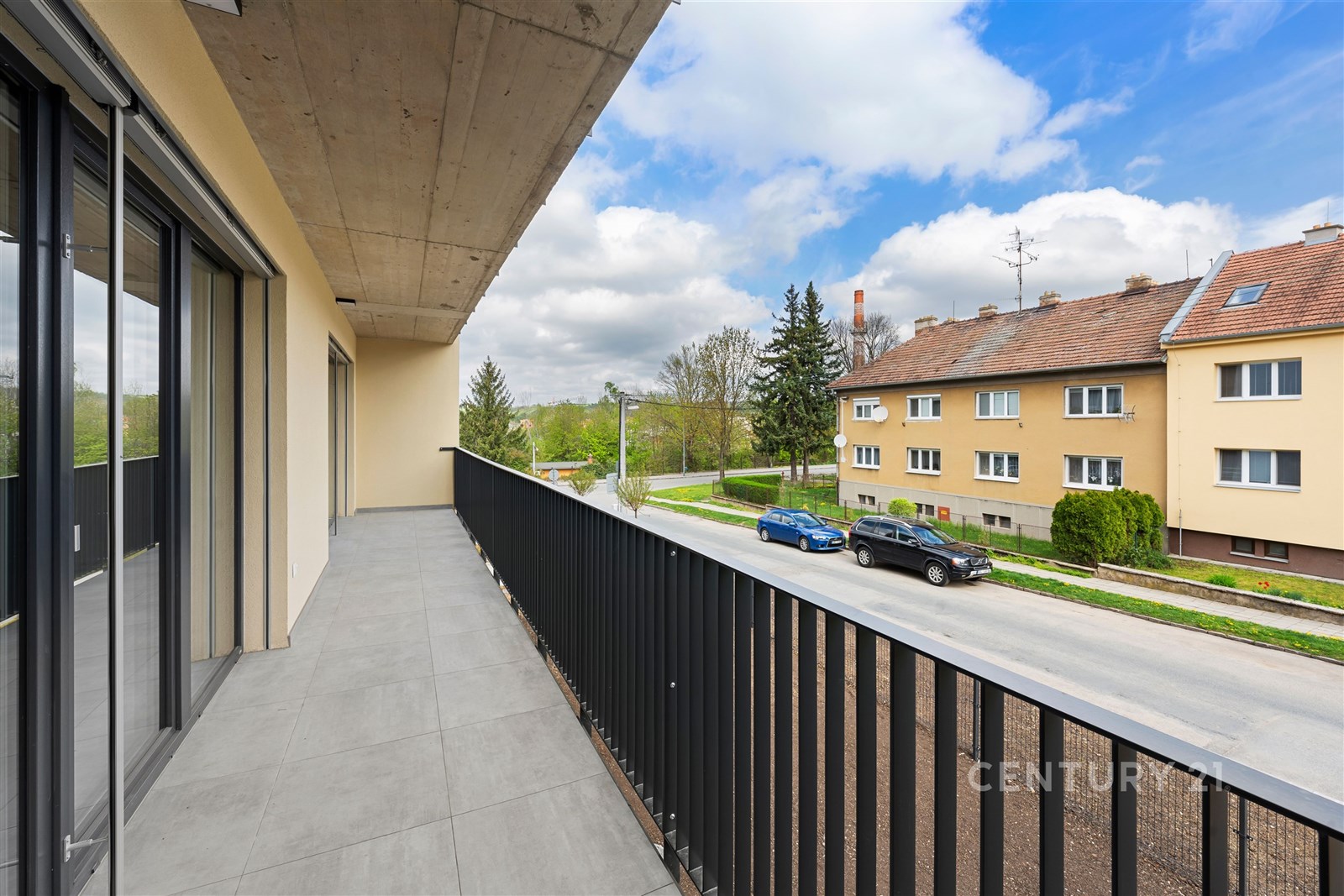Prostorný balkon s moderní dlažbou, kovovým zábrad
