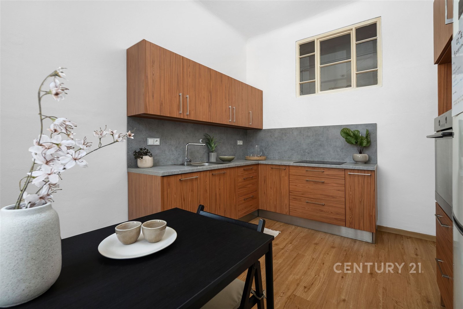 Kompaktní kuchyň s dřevěnými skříňkami, šedou prac