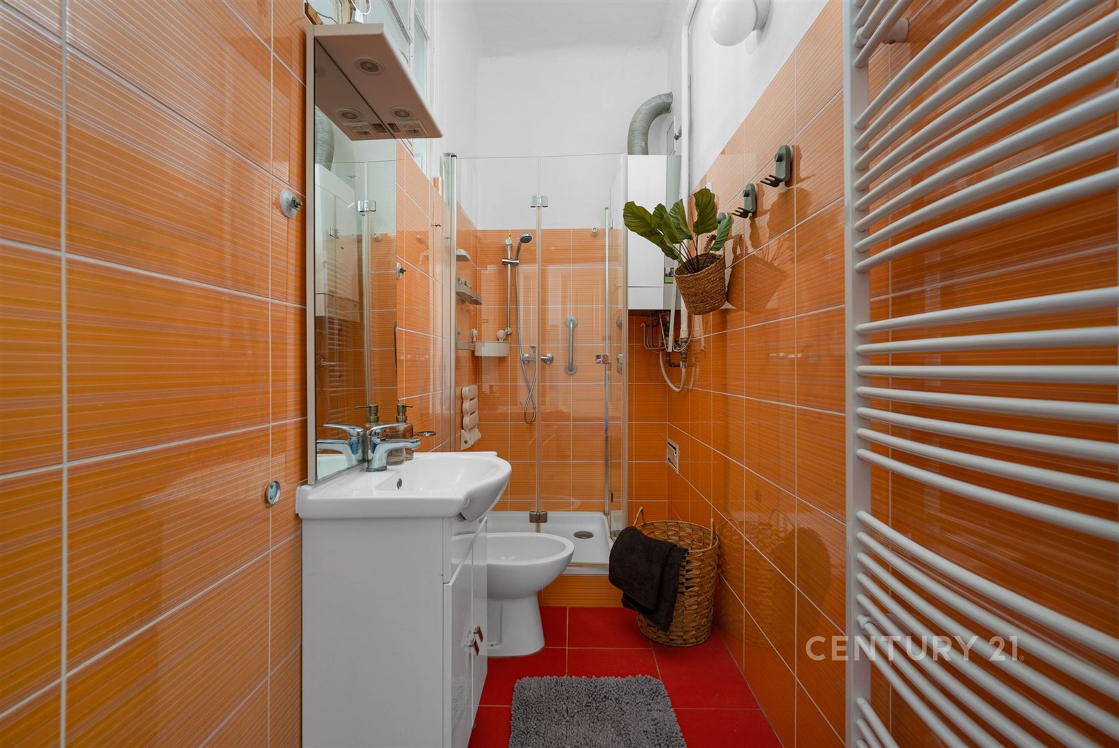Moderní koupelna s oranžovými dlaždicemi, prosklen