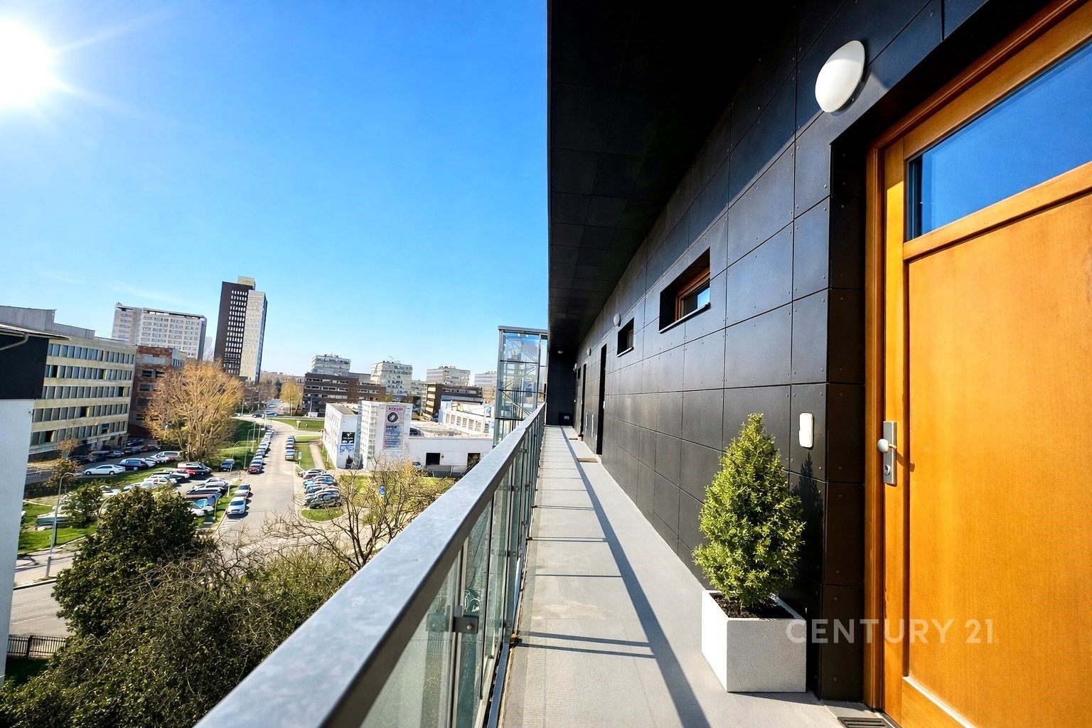 Průchozí balkon s moderním zábradlím a výhledem na