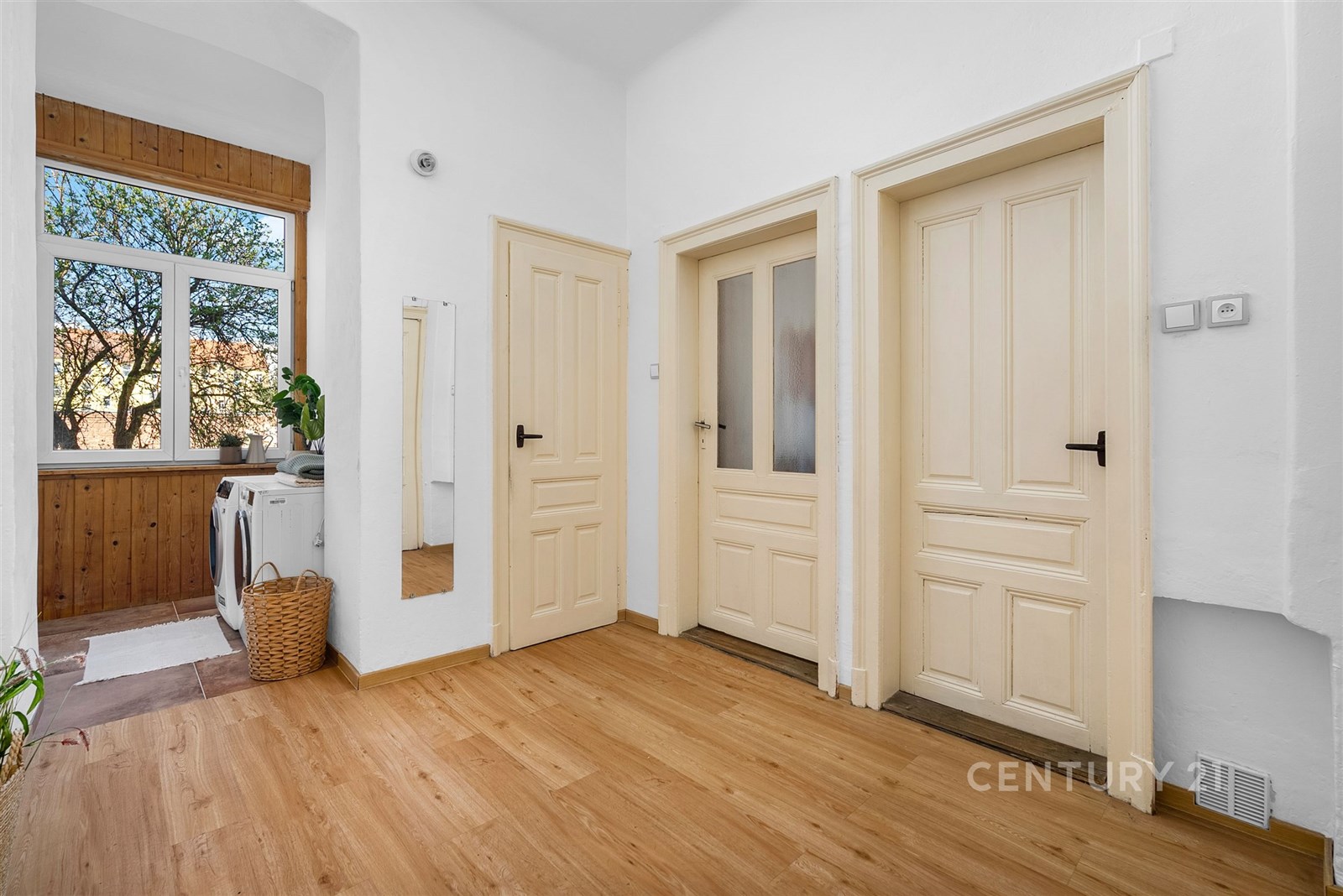 Světlá vstupní hala s parketovou podlahou, velkým 