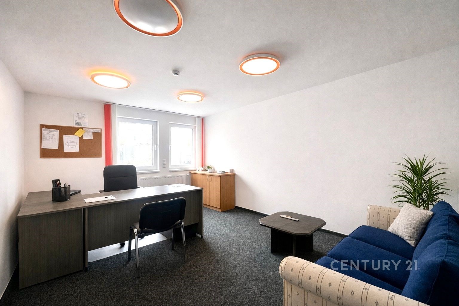 Kancelářský prostor s moderním nábytkem, velká okn