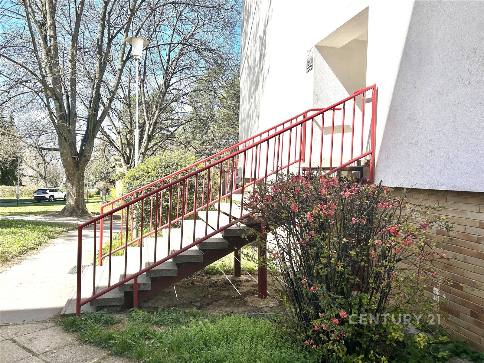 Exteriér bytového domu s venkovním schodištěm a zd