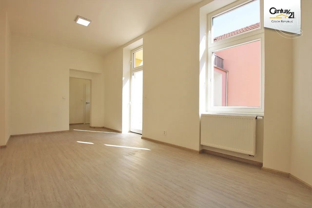 prázdná místnost s radiátor, přirozené světlo, a dřevěná podlaha