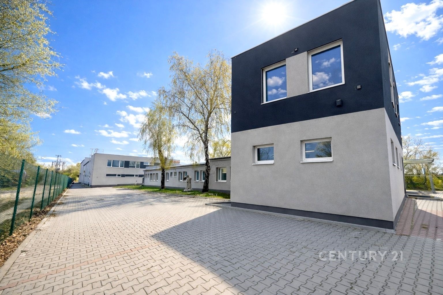 Průmyslová budova s moderní fasádou a dlážděným pa