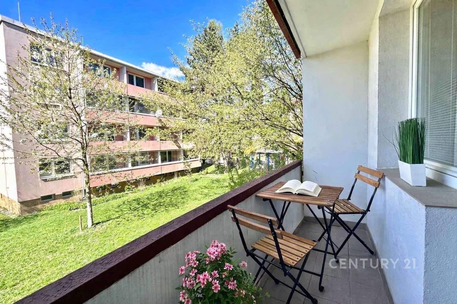 Zasklený balkon s výhledem na zeleň, dlažba a mode