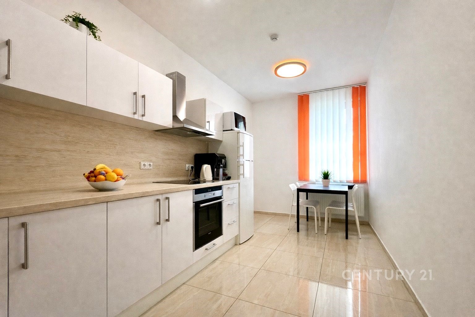 Moderní kuchyň s dlažbou, bílými skříňkami a vesta