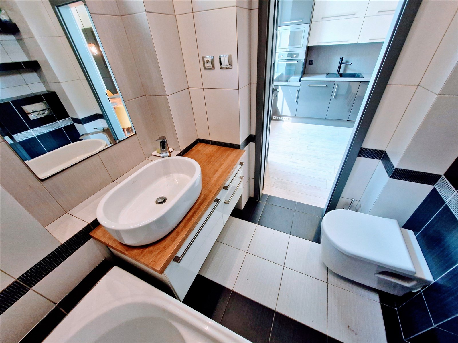 Moderní koupelna s dlažbou, bílým umyvadlem a eleg