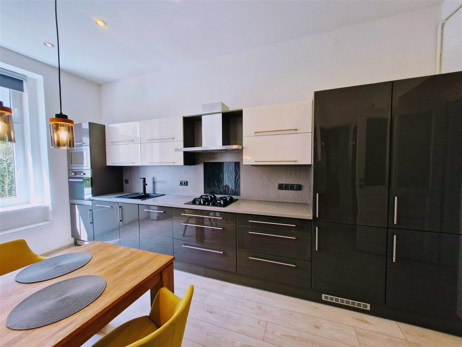 Moderní kuchyň s lesklou černou a bílou linkou, ve