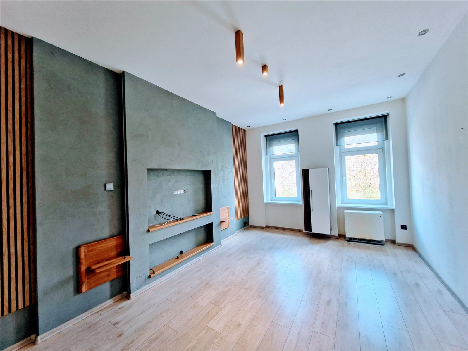 Světlý obývací pokoj s parketovou podlahou, velkým