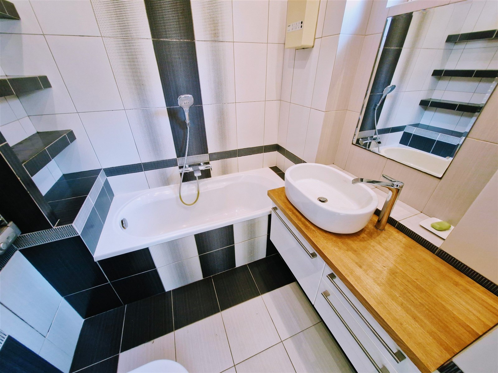 Moderní koupelna s dlažbou, vestavěnou vanou a sty