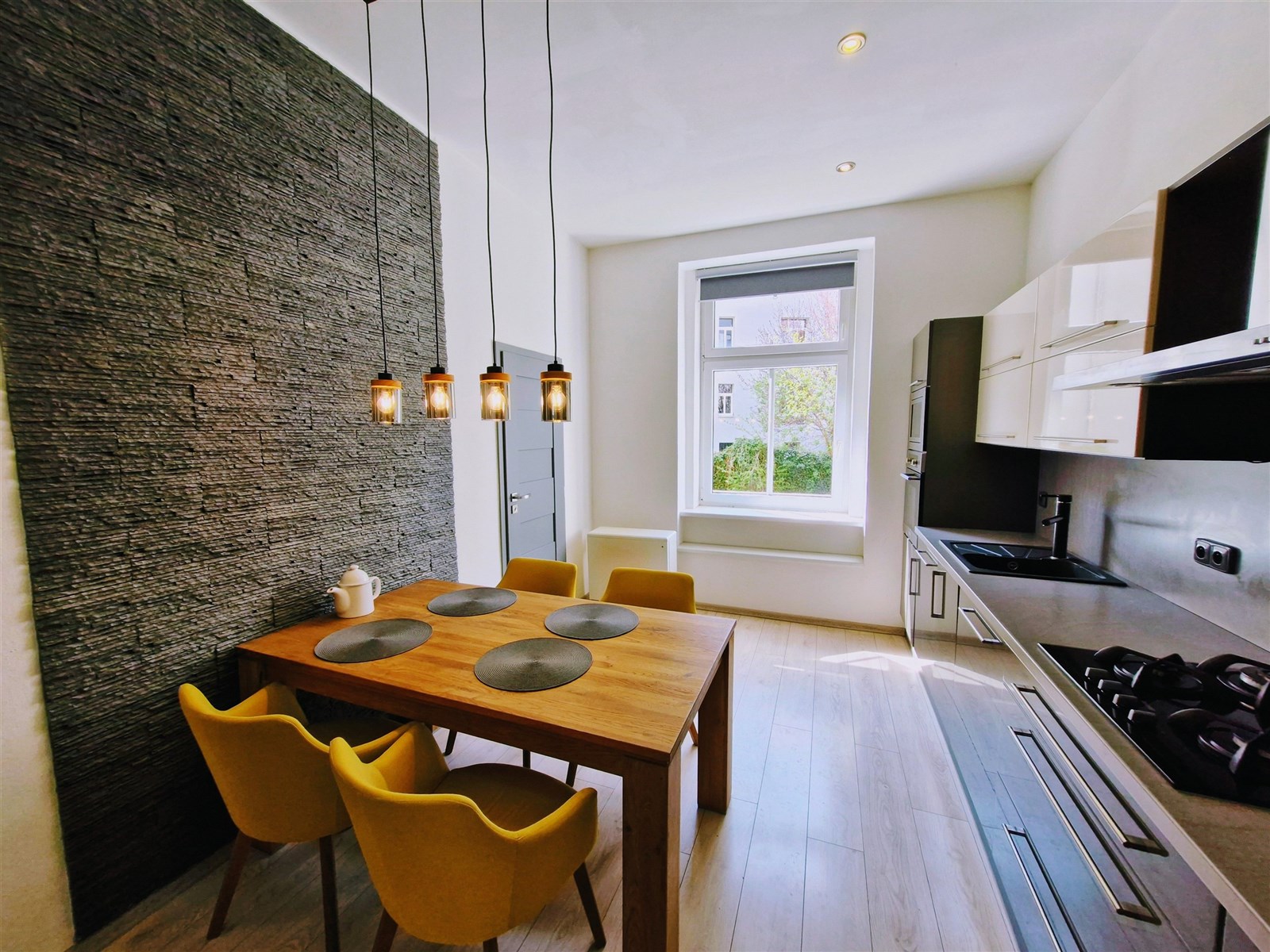 Moderní kuchyň s dřevěným jídelním stolem, parketo