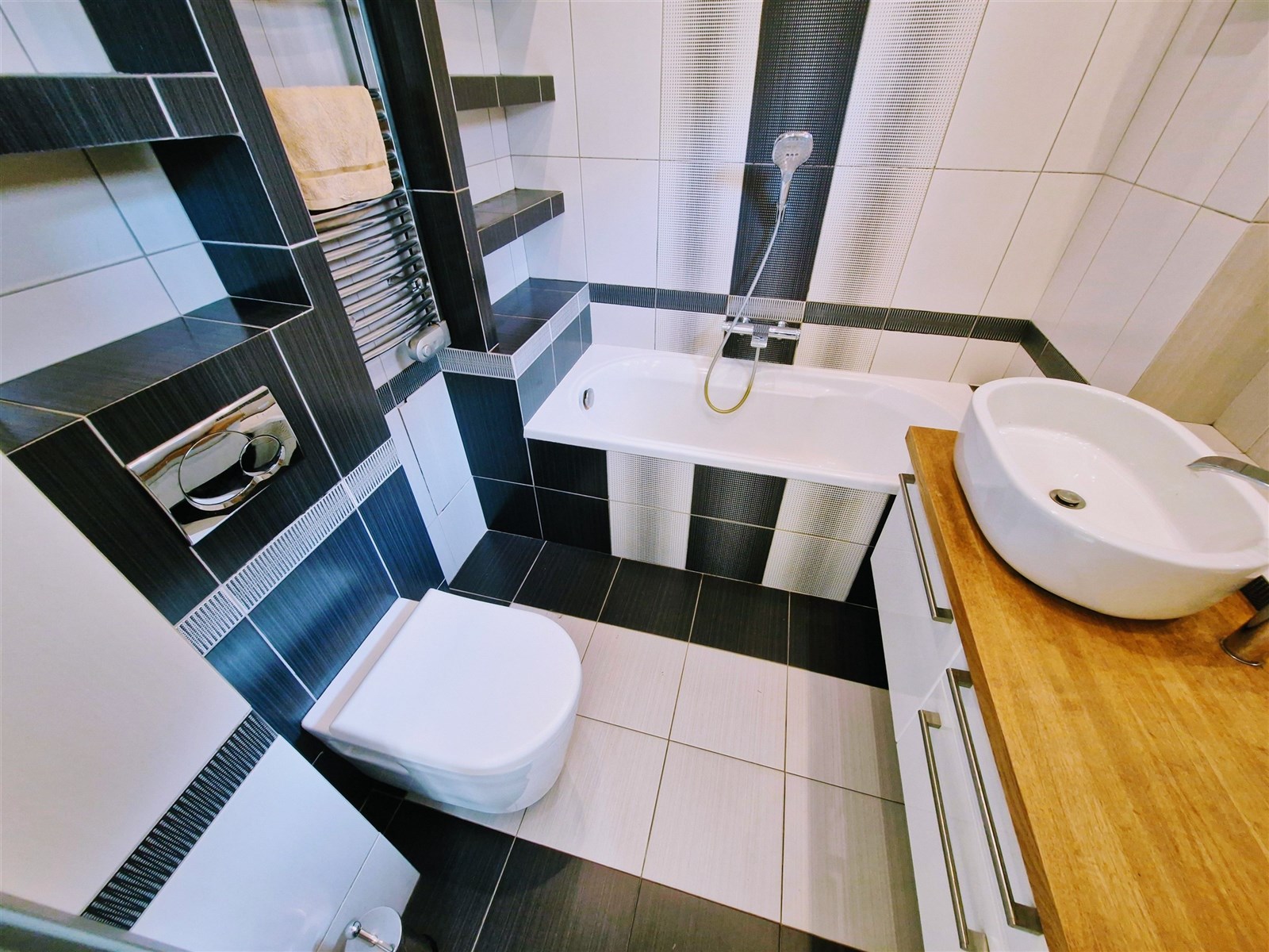 Moderní koupelna s dlažbou, závěsnou toaletou a dř