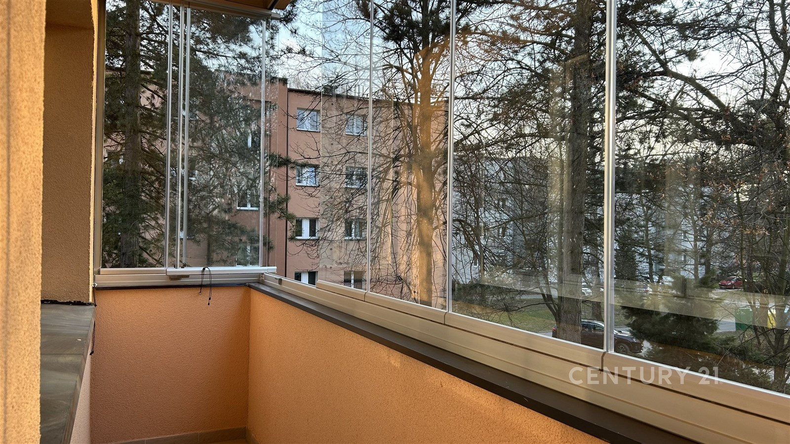 Zasklený balkon s výhledem na tiché okolí, dlažba 