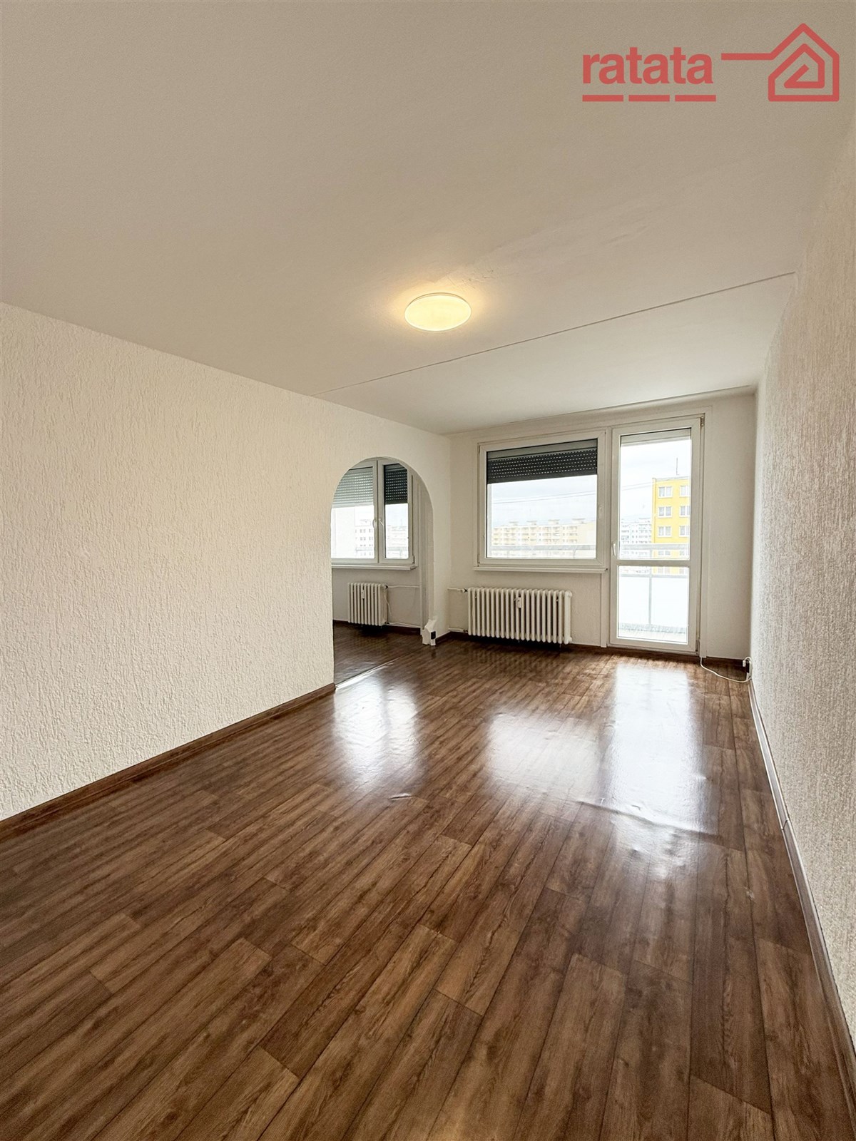 Prostorný obývací pokoj, parketová podlaha, velká okna, moderní světlý interiér, připravený k úpravám dle vlastních potřeb