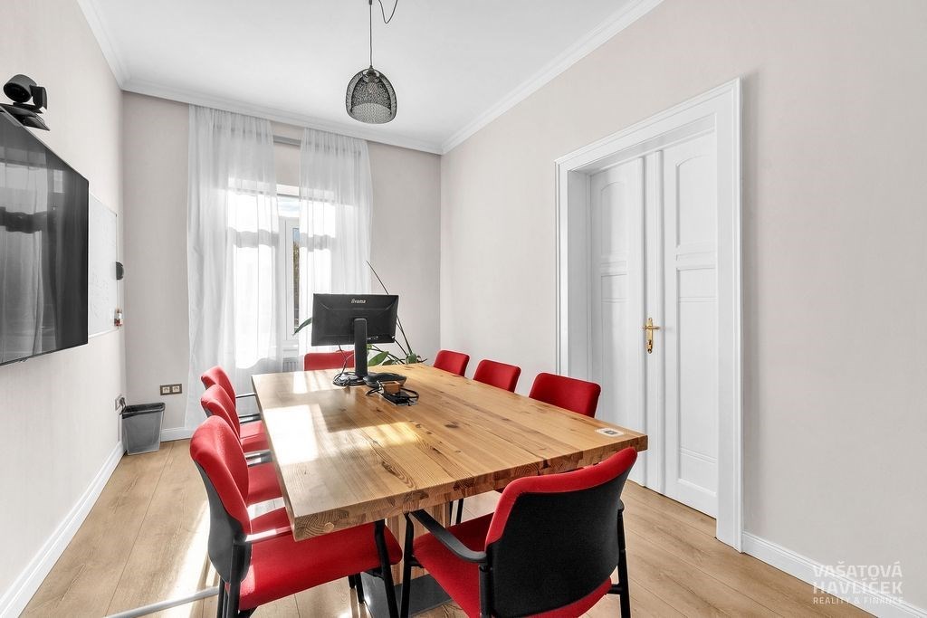 Zasedací místnost s dřevěným stolem, moderními žid