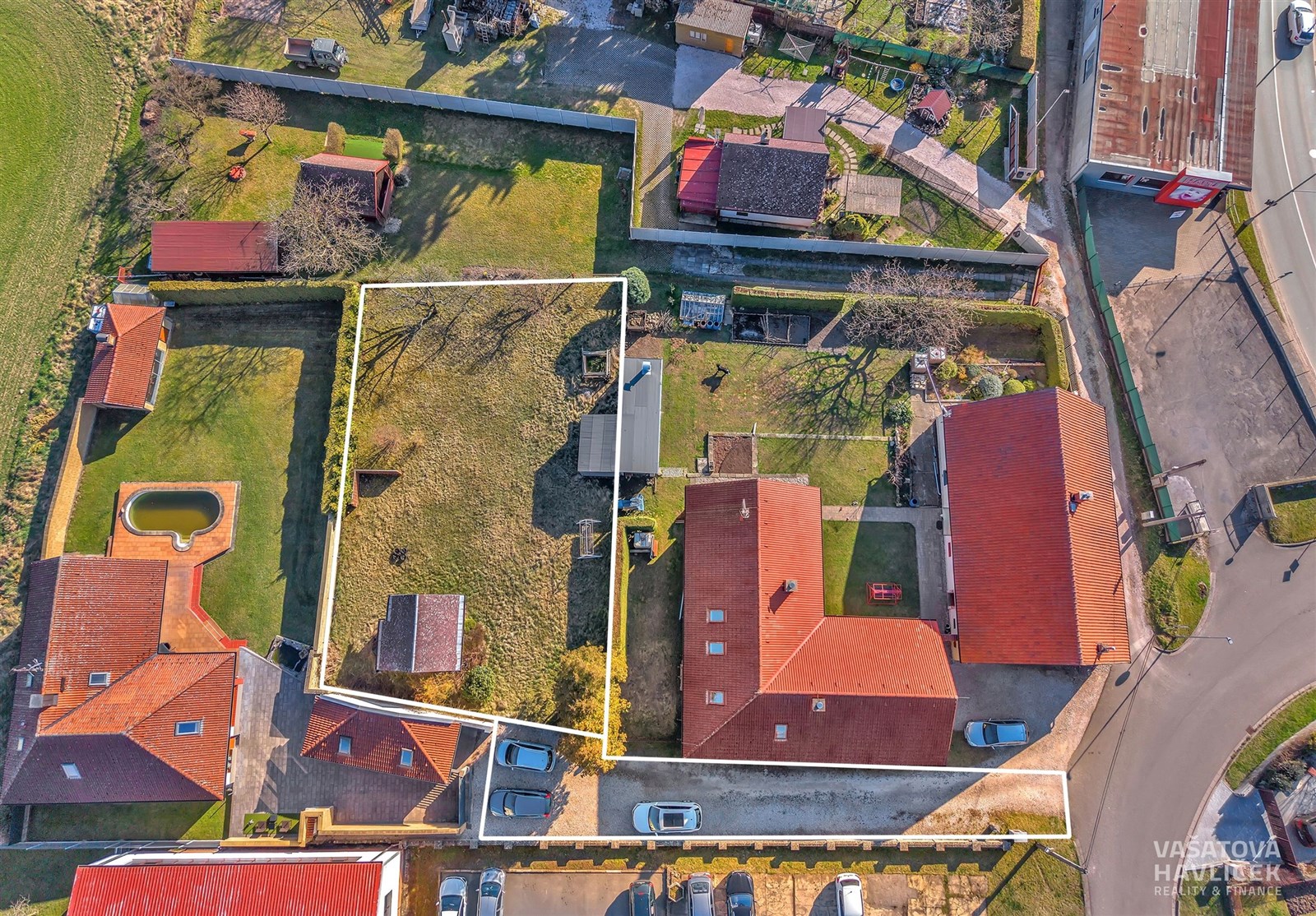 Pozemek s rovinatou travnatou plochou, obklopený p