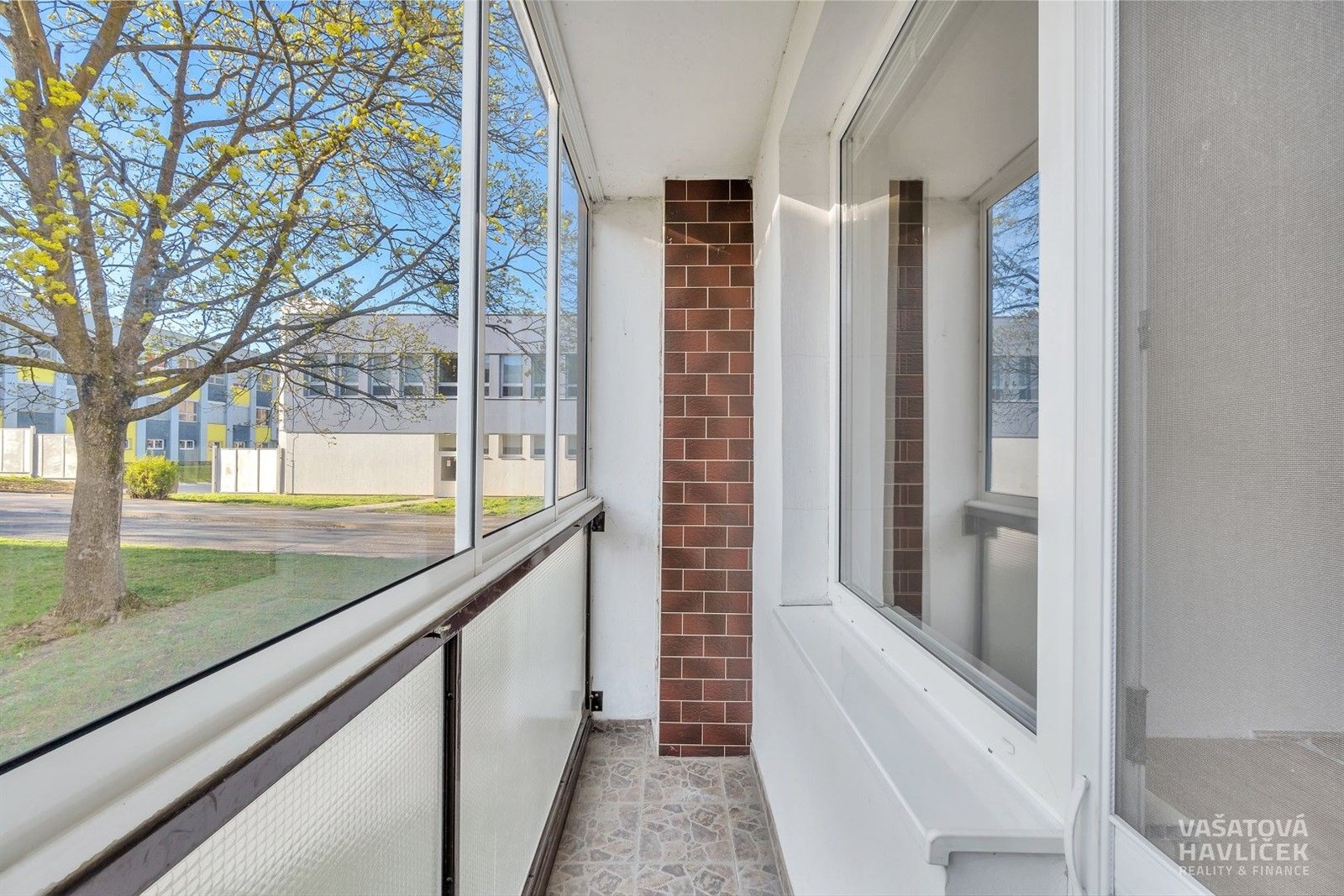 Zasklená lodžie s dlažbou a cihlovým obkladem nabí