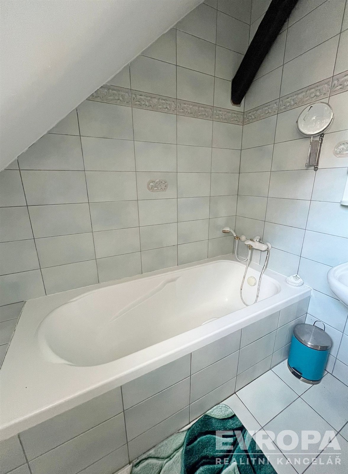 Koupelna se šikmým stropem, keramická dlažba, bílá