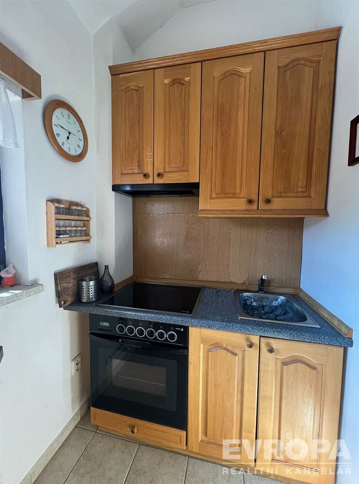 Malá kuchyň s dřevěnými skříněmi, elektrickým spor