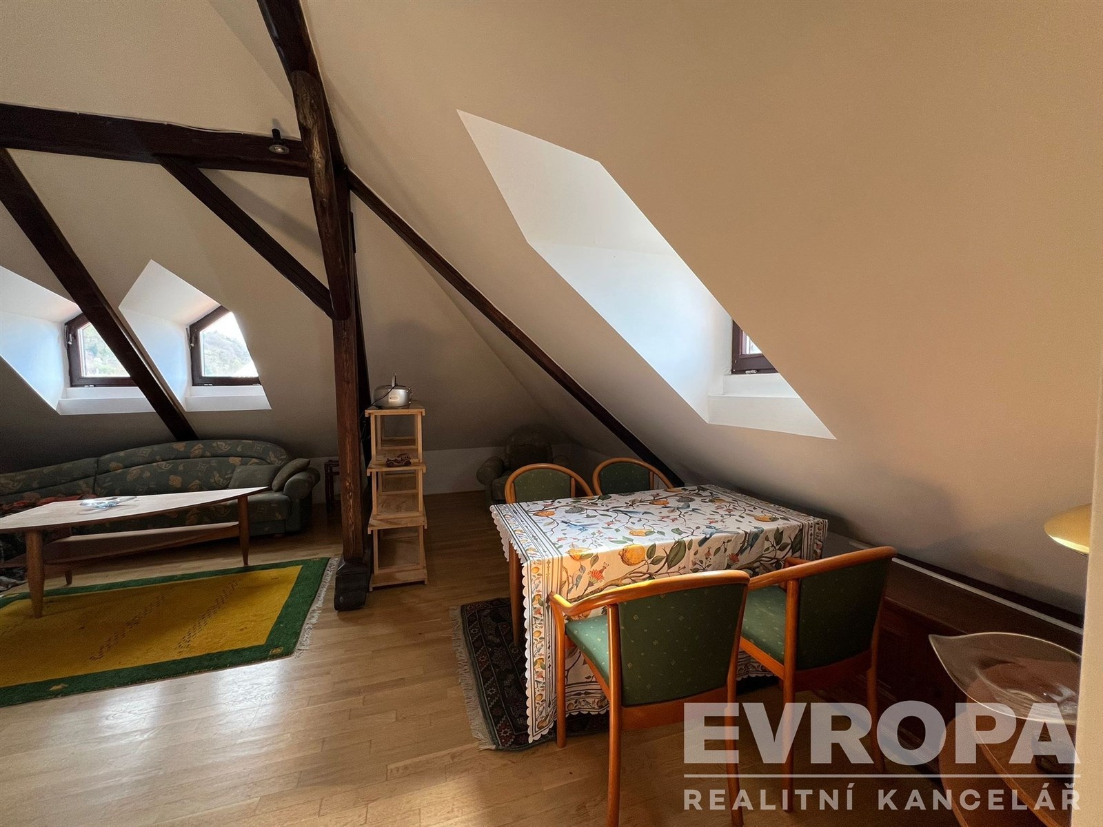 Podkrovní obývací pokoj s parketovou podlahou a dř