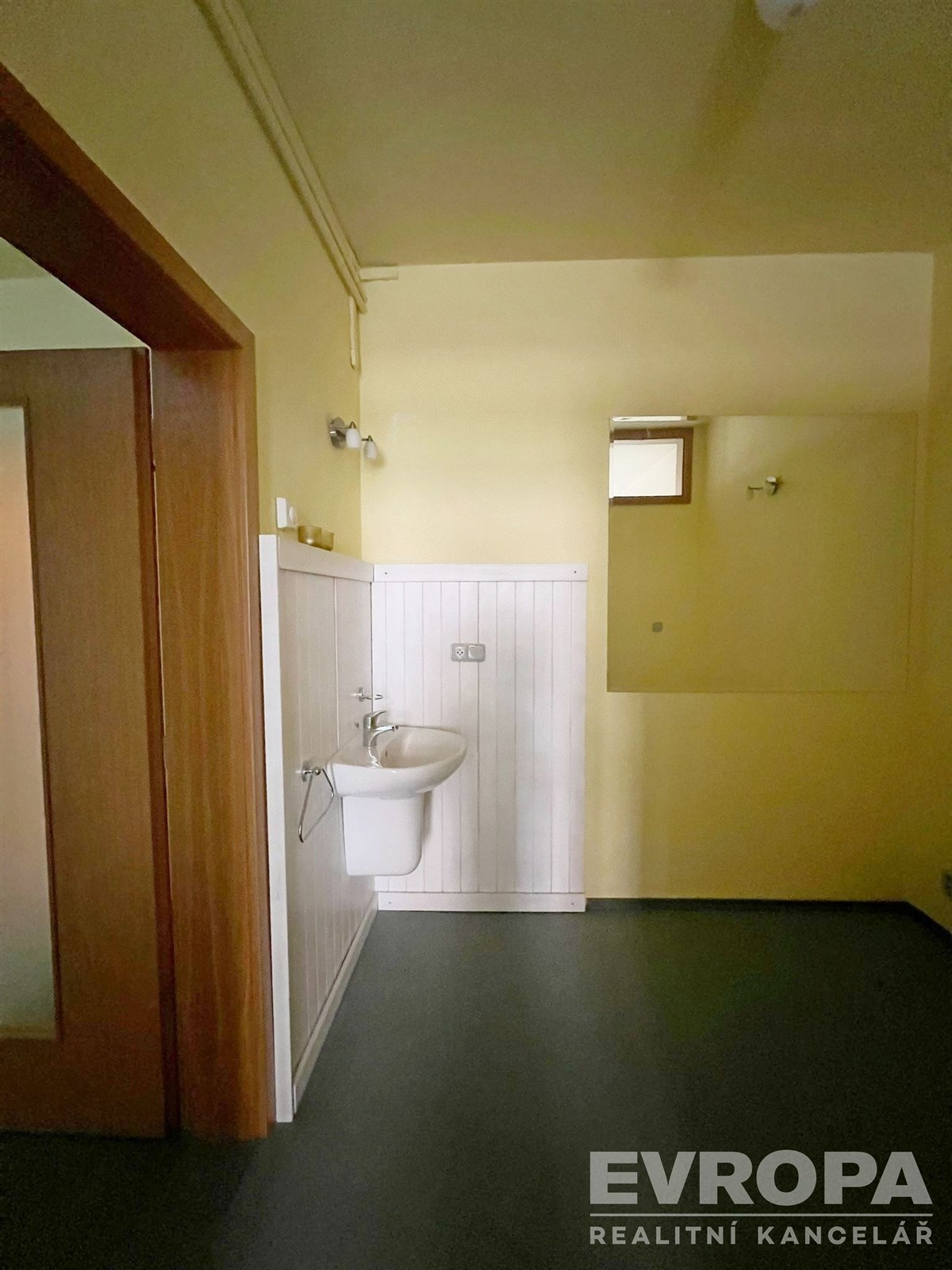 Malá koupelna s umyvadlem, dlažba a dřevěné obložení, účelný styl