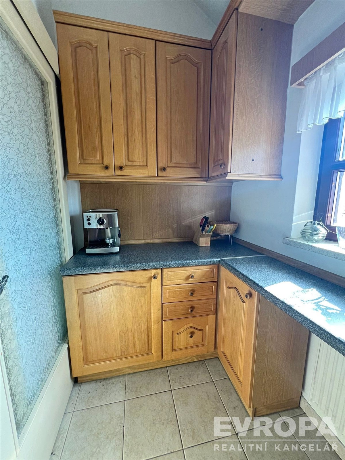 Kuchyň s dřevěnými skříňkami, moderními spotřebiči