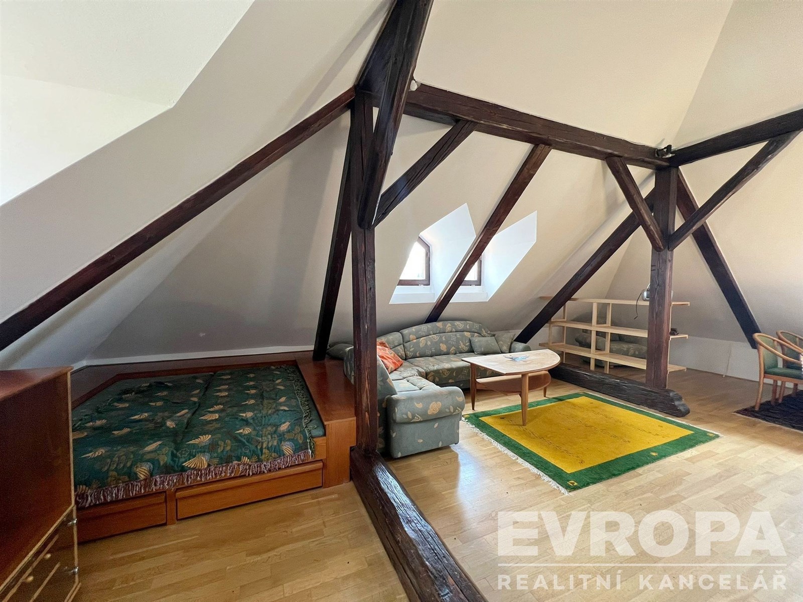 Prostorná podkrovní místnost s parketovou podlahou