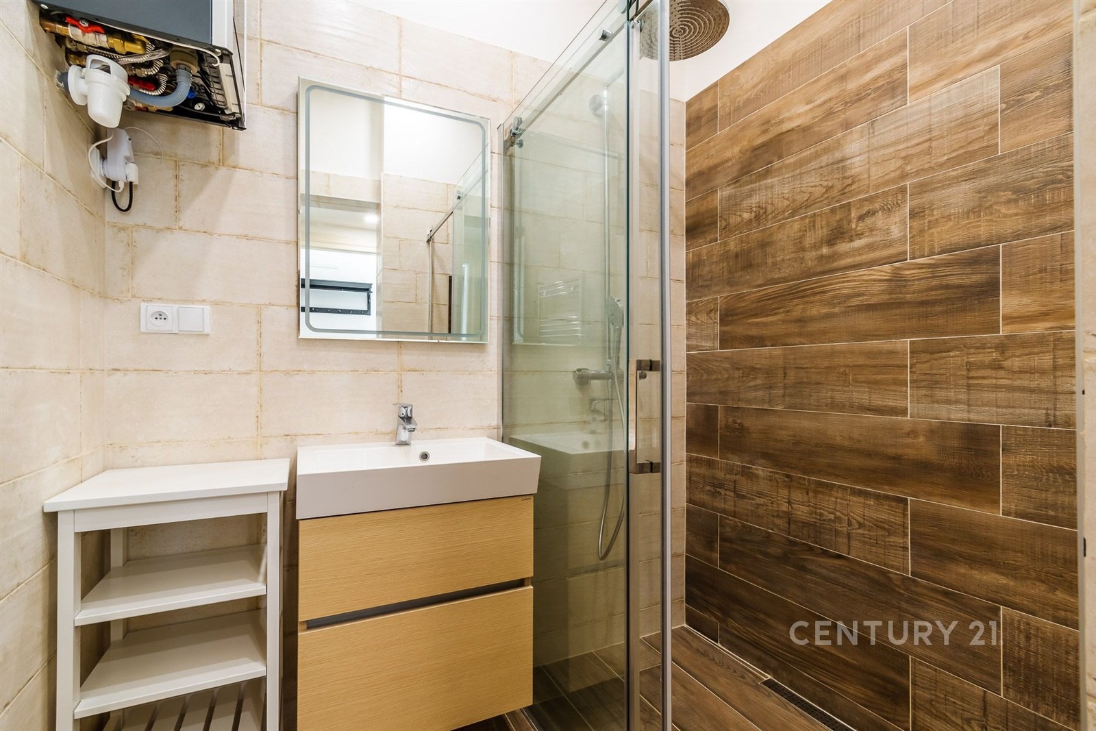 Moderní koupelna s dřevěným obkladem, skleněným sprchovým koutem a světlým nábytkem, elegantní a rekonstruovaný prostor.