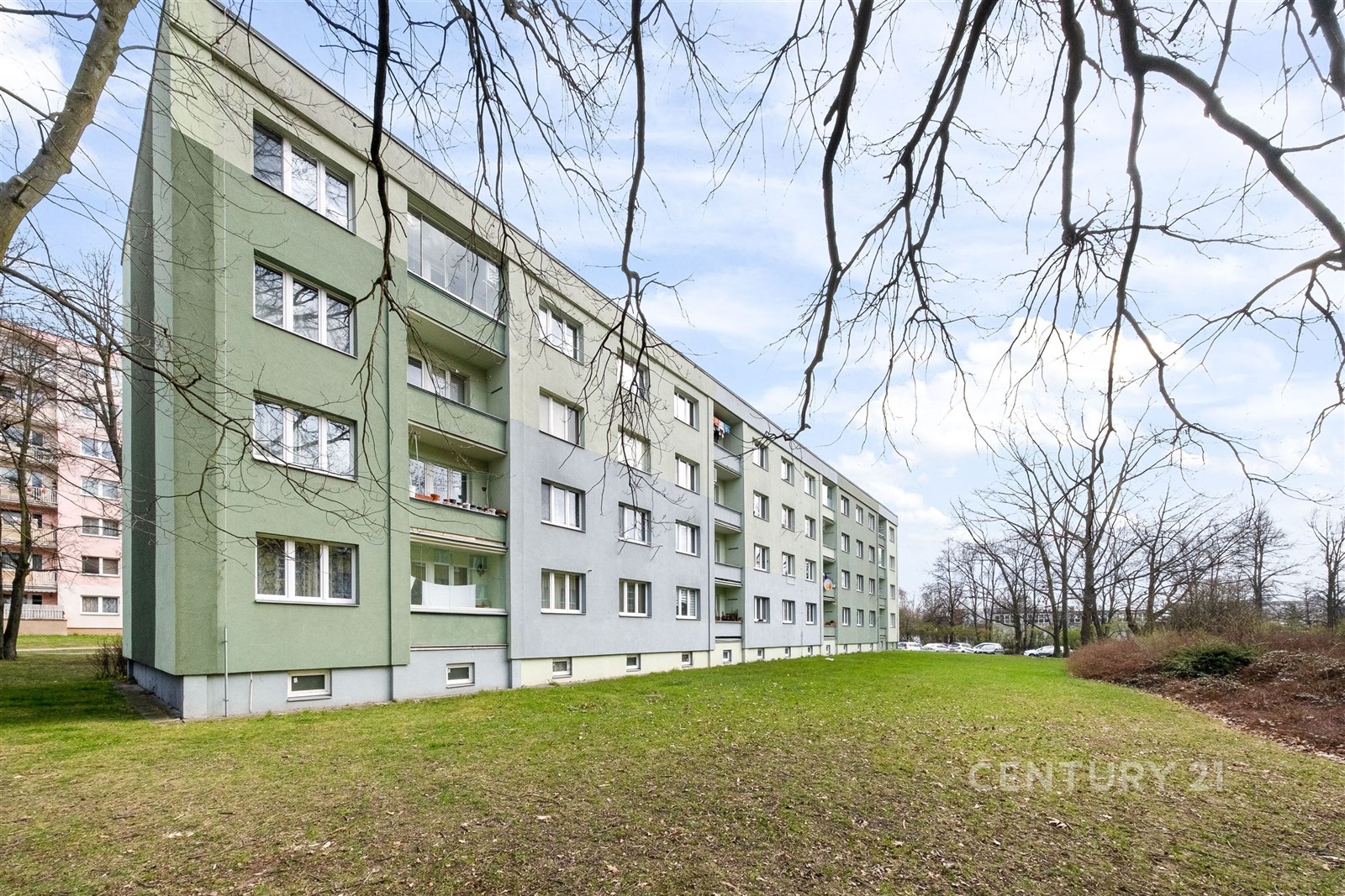 Bytový dům s moderní fasádou a velkými okny, obklo