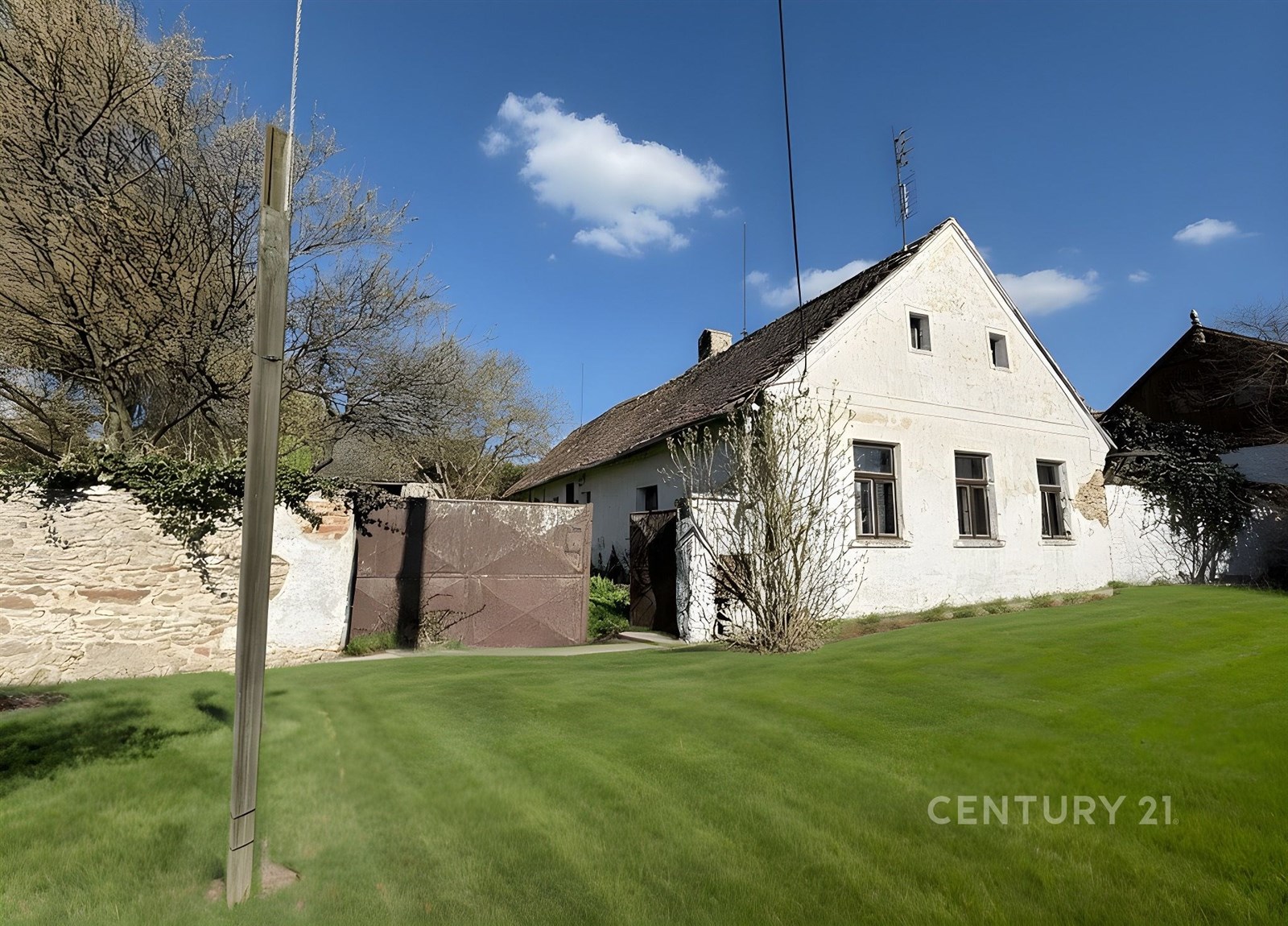 Tradiční venkovský dům s bílou fasádou, šikmou stř