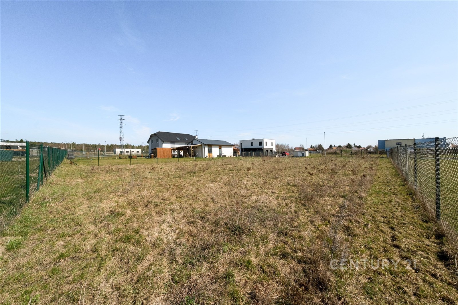 Stavební pozemek s rovinatým terénem, oplocením a 