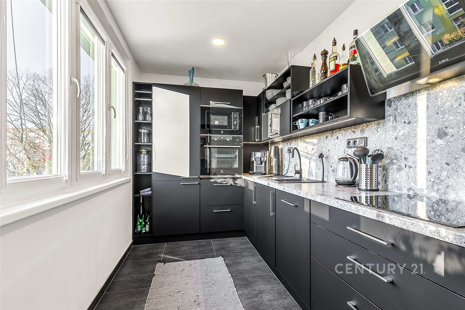 Moderní kuchyň s dlažbou, vestavěnými spotřebiči a