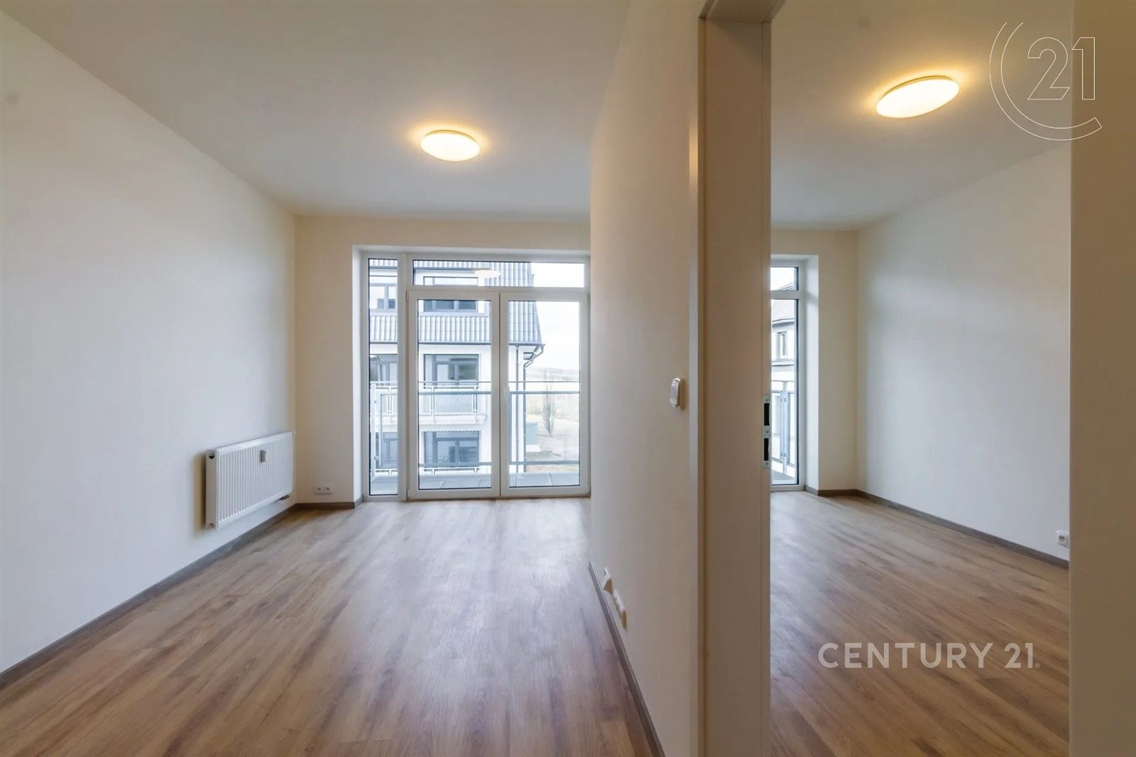 prázdná místnost s radiátor, přirozené světlo, a dřevěná podlaha