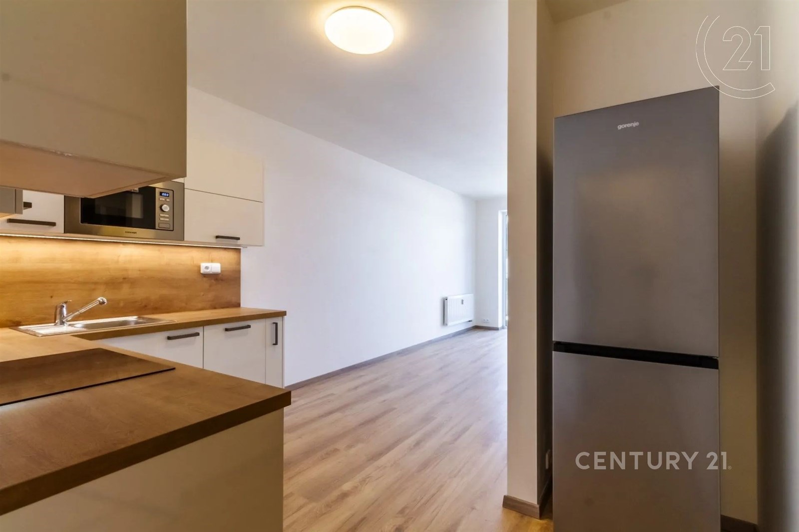 kuchyně s dřevěná podlaha, dřez, a bílé skříně