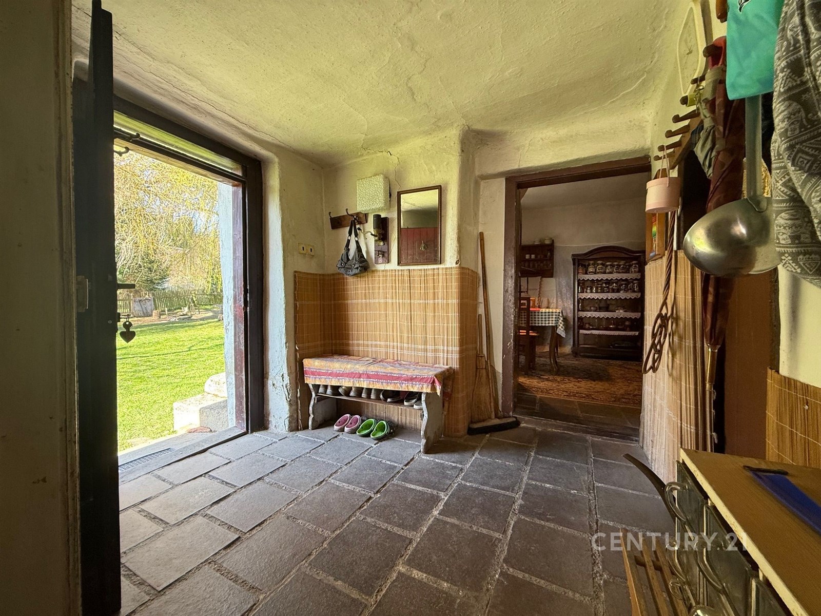 Vstupní chodba s dlažbou, otevřeným vchodem na zah