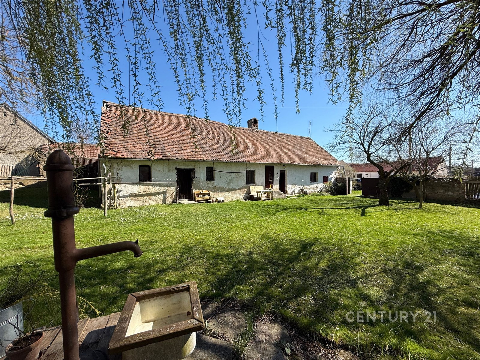 Tradiční venkovský dům s terakotovou střechou a ka