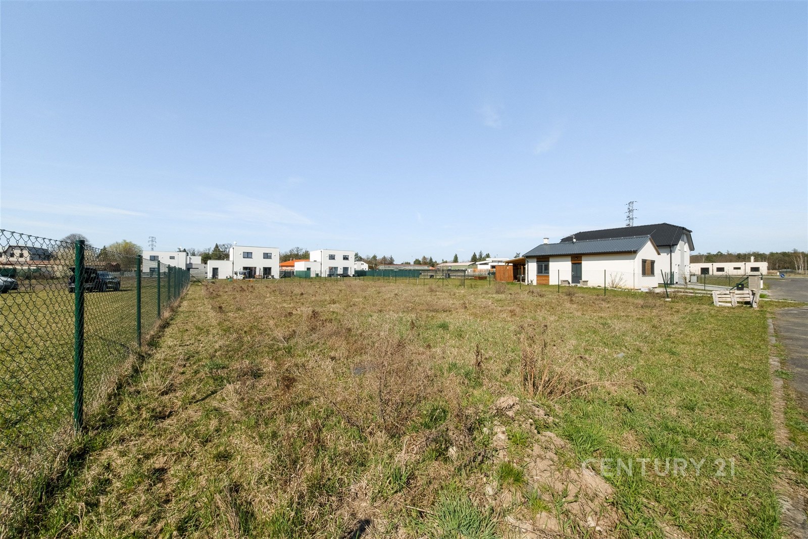 Stavební pozemek s travnatým povrchem, oplocený, v