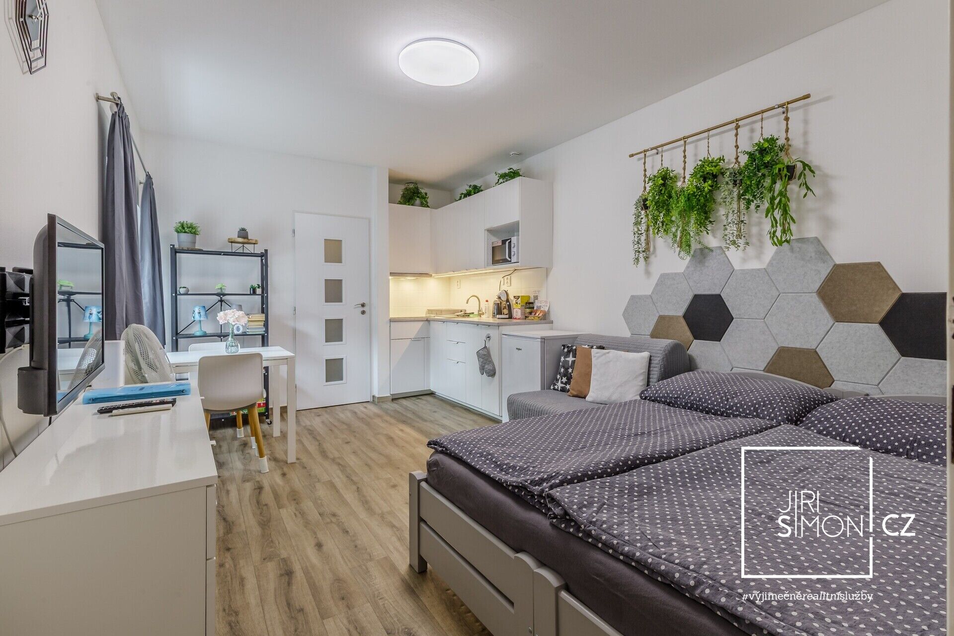 Celkový pohled na obytnou část apartmánu s postelí a kuchyní