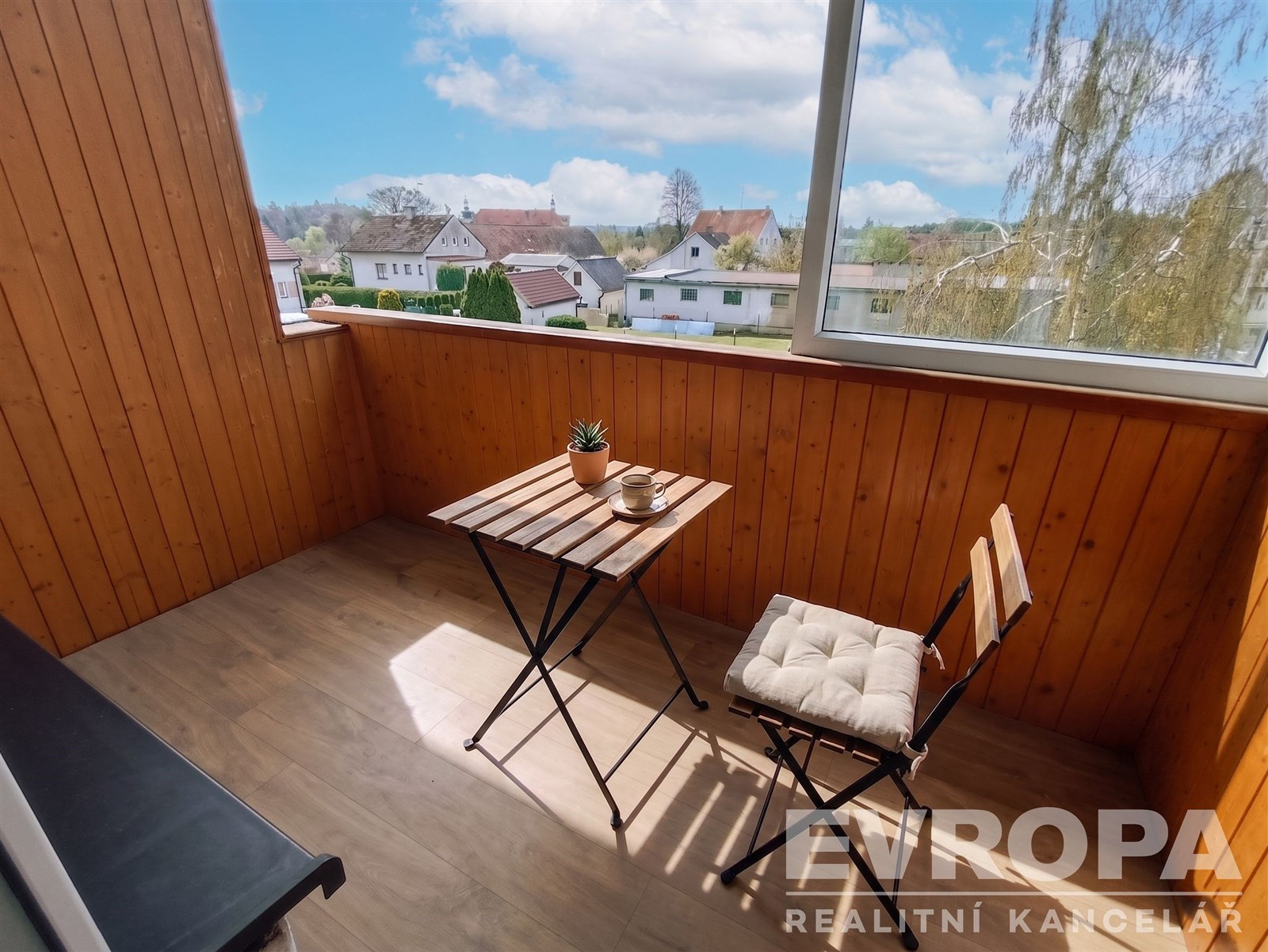Zasklený balkon s dřevěným obložením nabízí útulný