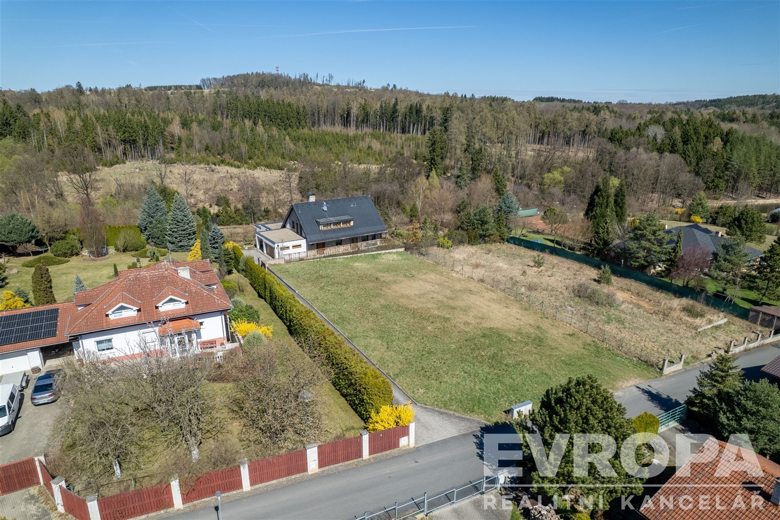 Stavební pozemek obklopený přírodou, rovinatý terén s výhledem na lesy, klidná lokalita, ideální pro rodinný dům nebo rekreační chalupu.