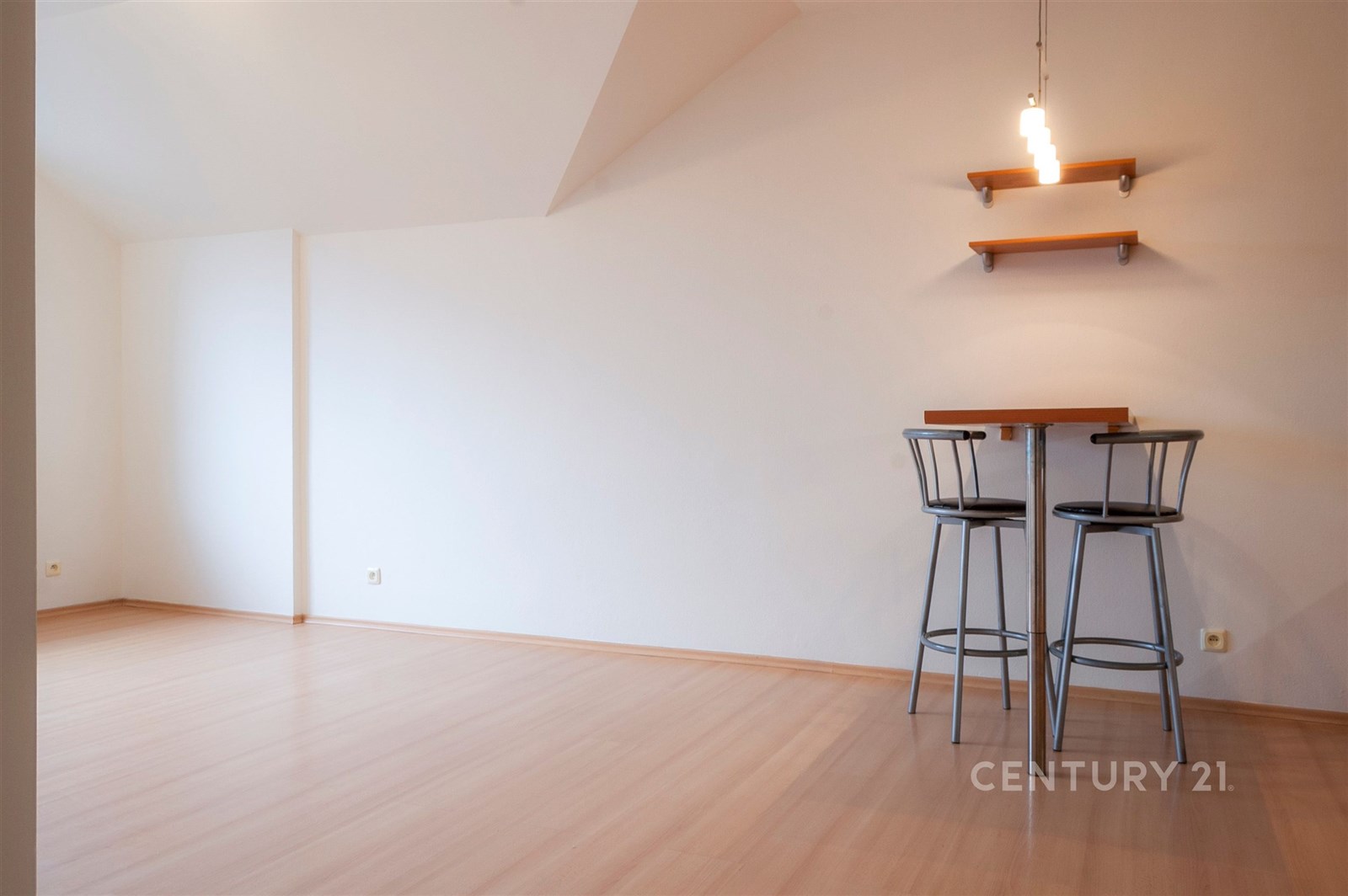 Prostorný světlý obývací pokoj s parketovou podlahou, moderními světly a minimalistickými detaily nabízí skvělý potenciál pro kreativní zařízení.