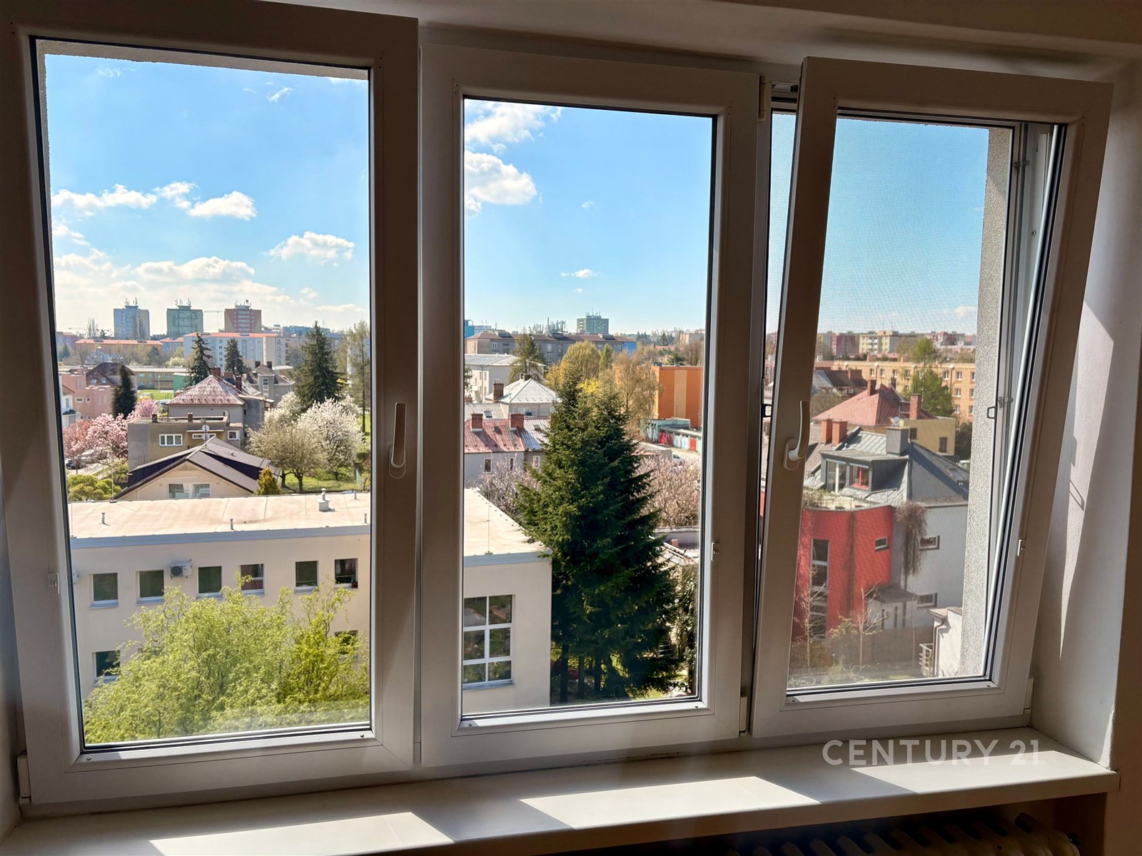 Velká okna nabízejí panoramatický výhled na město, zajišťují dostatek přirozeného světla a doplňují moderní design interiéru.