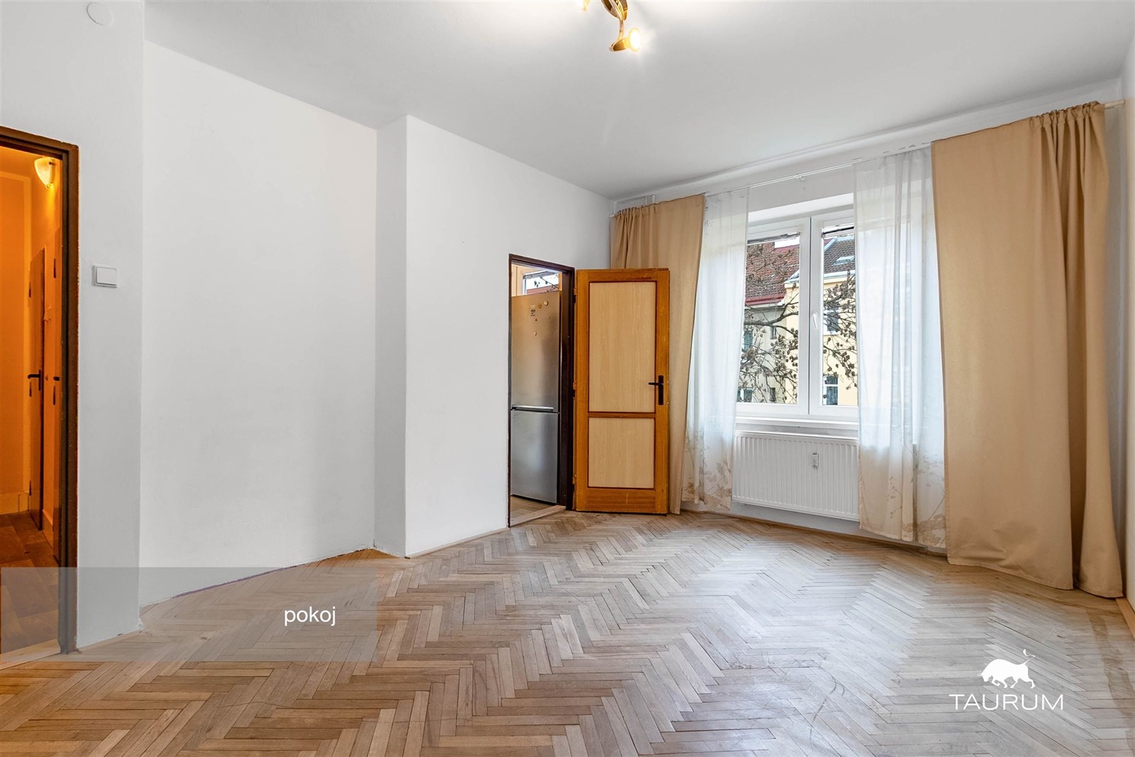 Prostorný pokoj s parketovou podlahou, velkými okn