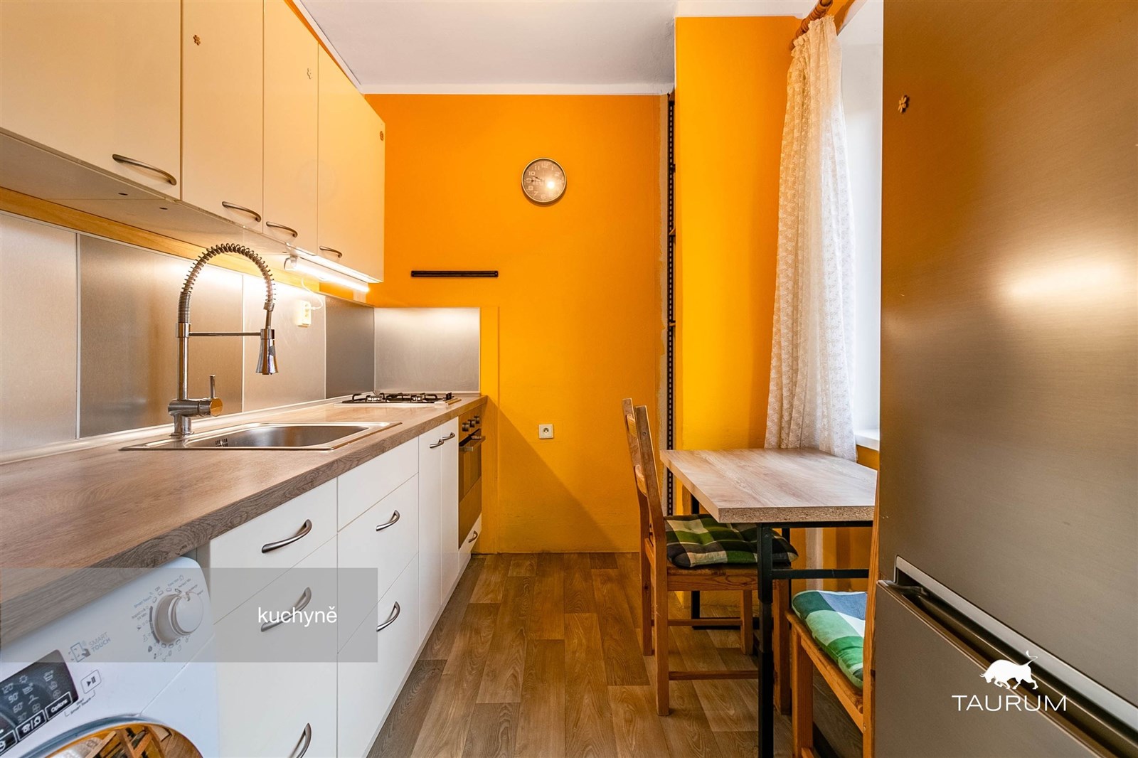 Kuchyně s dřevěnou podlahou, moderními spotřebiči 