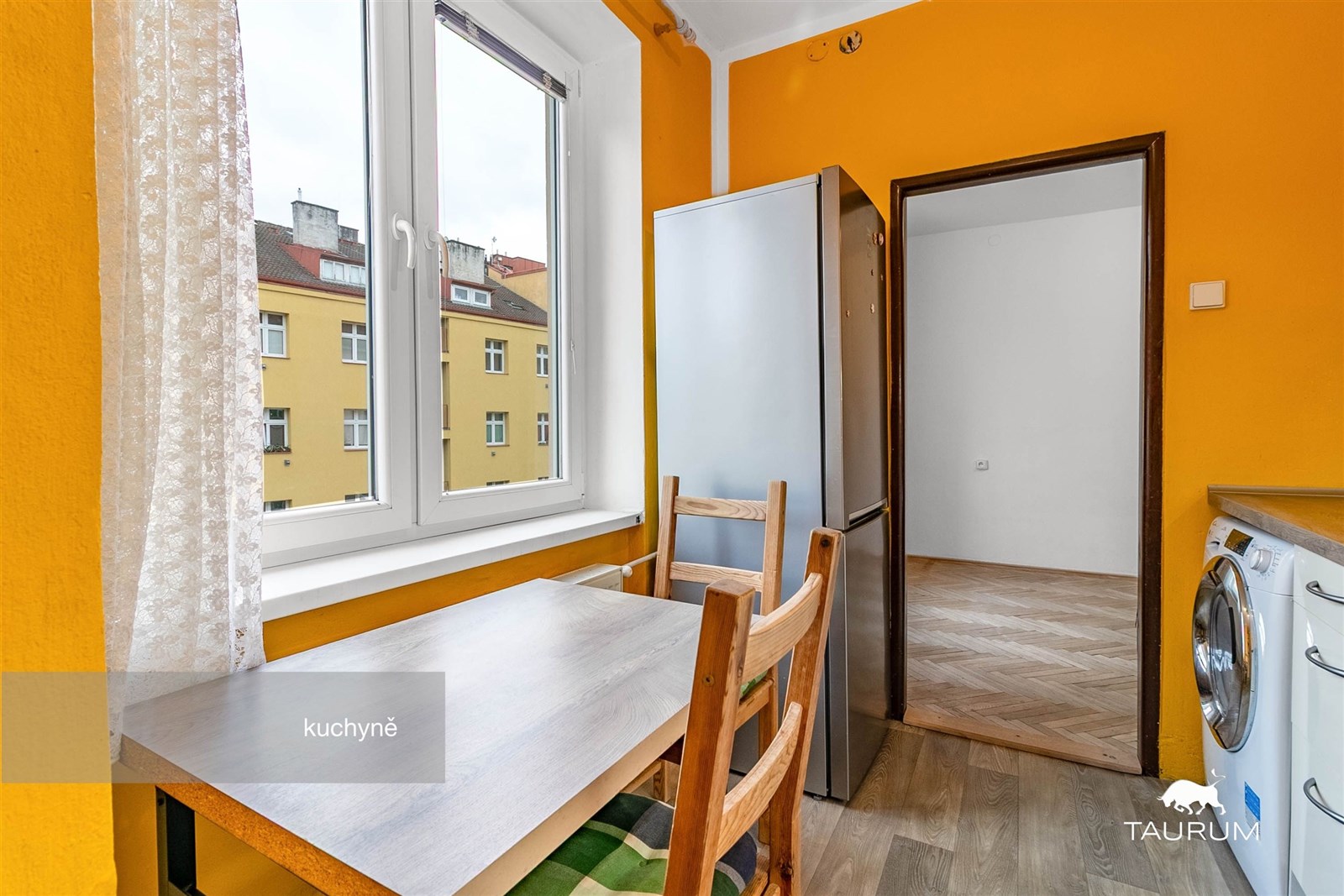 Světlá kuchyň s parketovou podlahou, velkými okny 