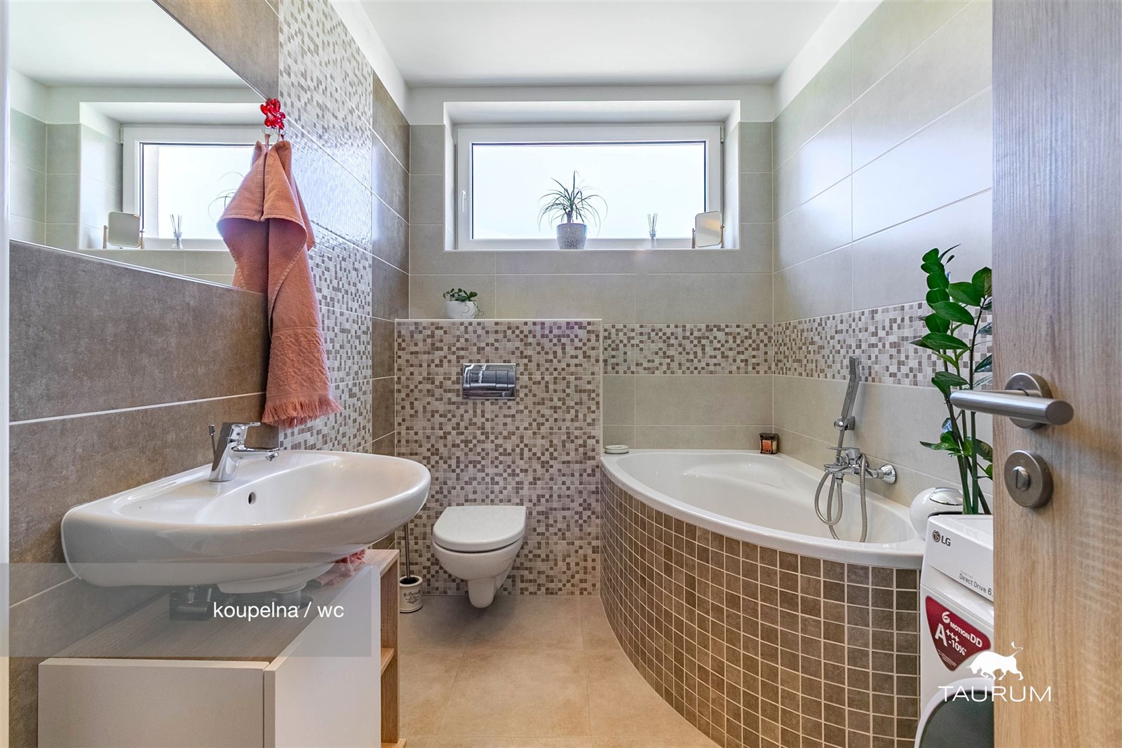 Moderní koupelna s dlažbou, rohovou vanou a velkým oknem. Světlé dlaždice a elegantní dekorativní obklady vytváří stylový design.