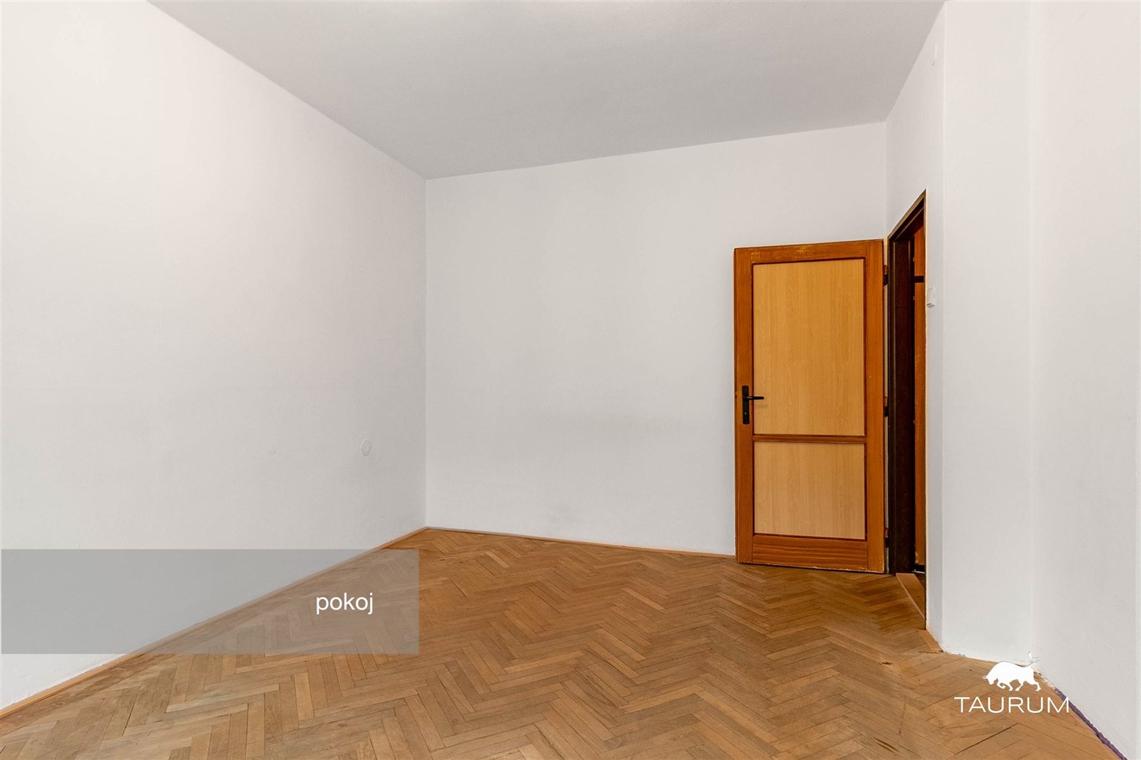 Světlý pokoj s parketovou podlahou a dřevěnými dve